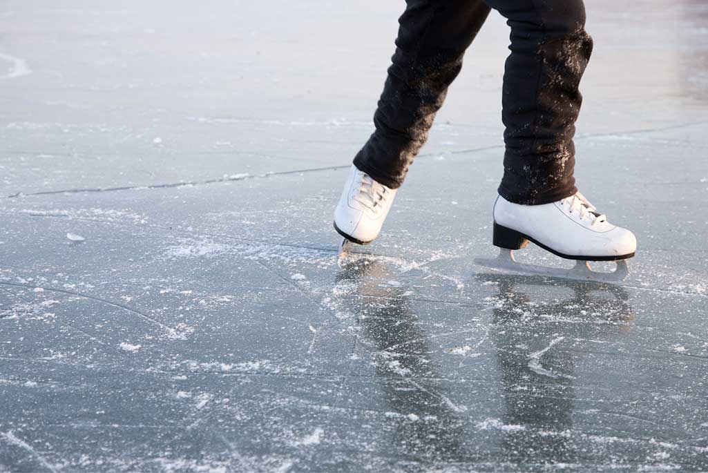 Foto på en person som åker skridskor utomhus på isen