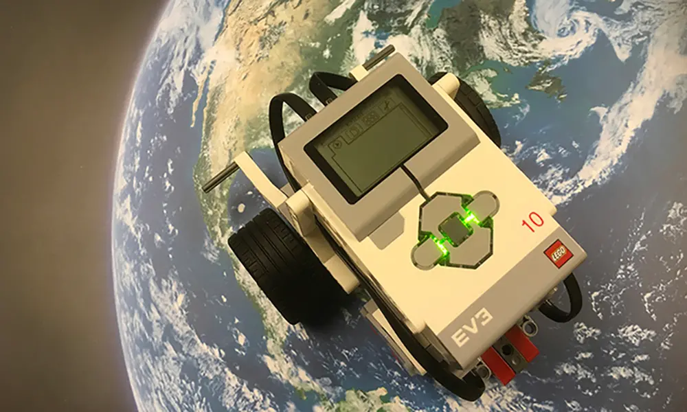 Foto på lego-robot som ser ut att köra på jorden.