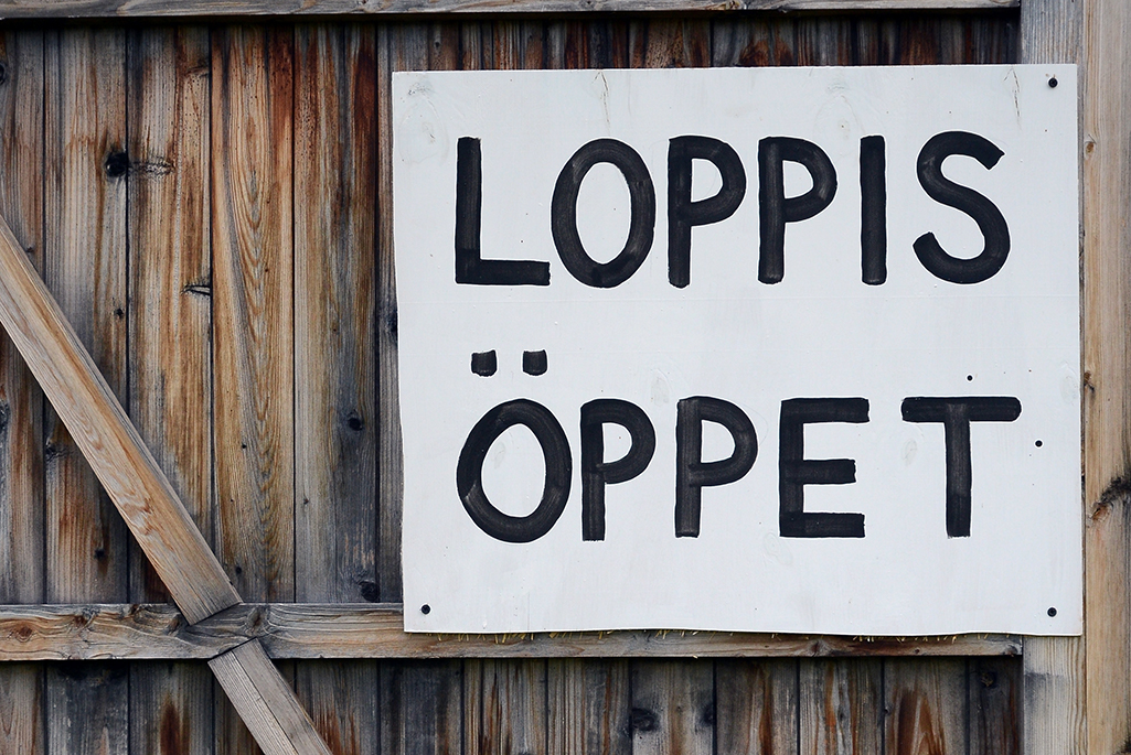 Foto på en skylt där det står Loppis Öppet. 