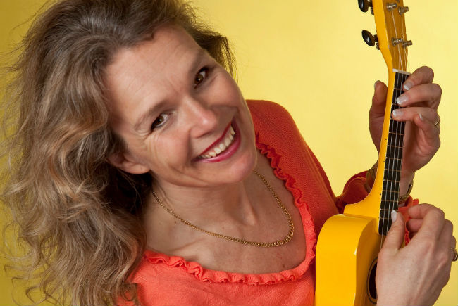 Bild på kvinna som spelar ukulele.