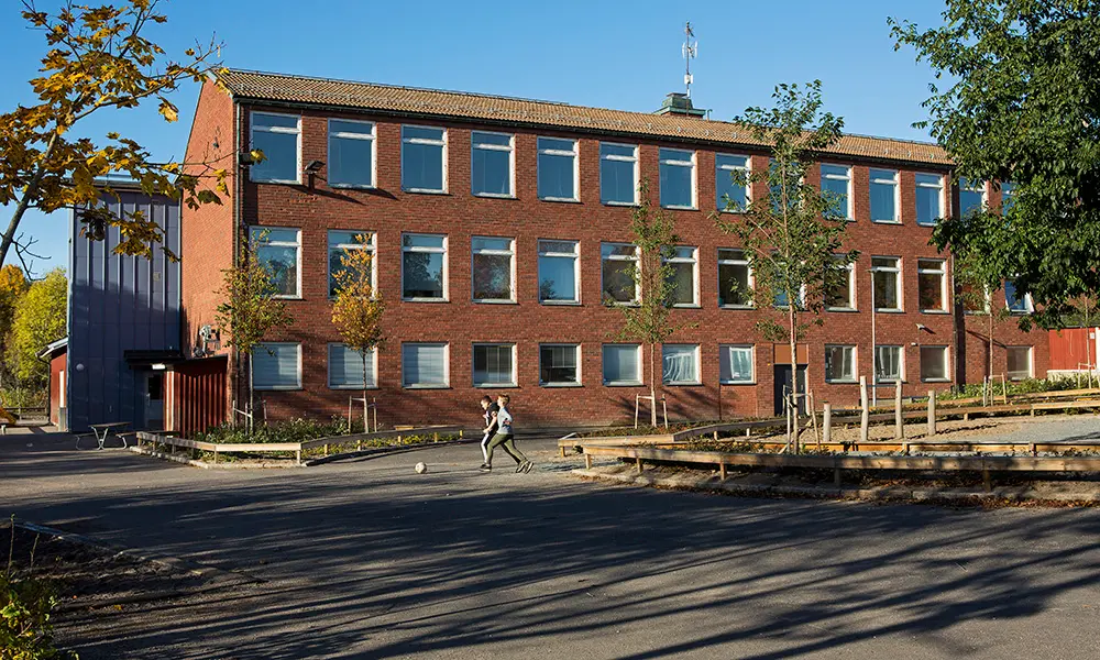 Foto av Hummelstaskolan. Det är en flervåningsbyggnad i rött tegel.