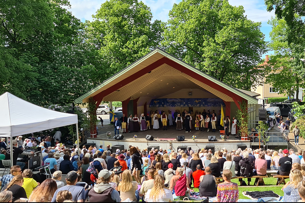 Bild på scenen och publik i Skolparken från nationaldagsfirandet 2023.