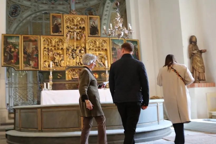 Foto på personer som går i en kyrka.